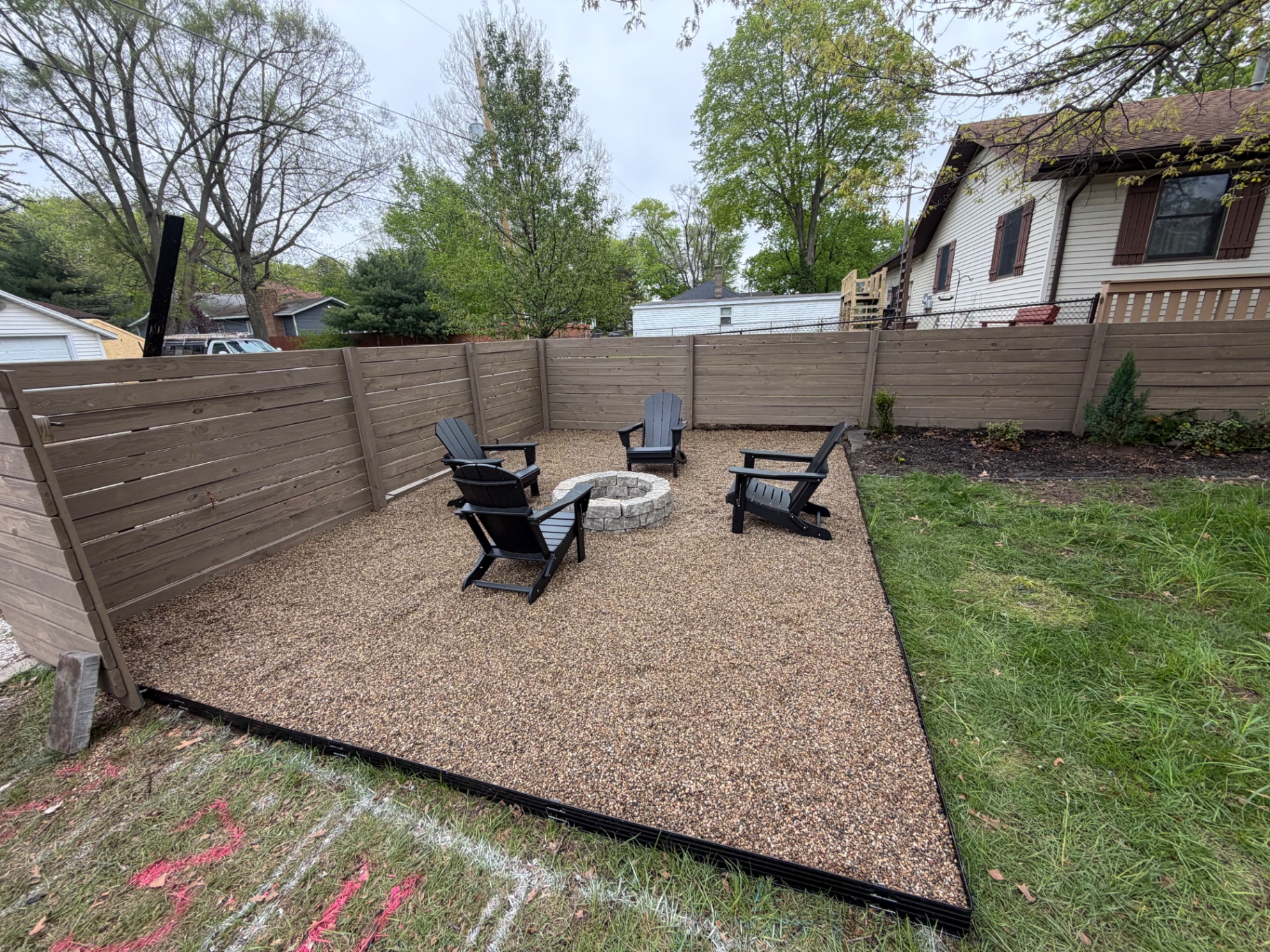 Pea gravel patio with stone fire pit and Adirondack chairs