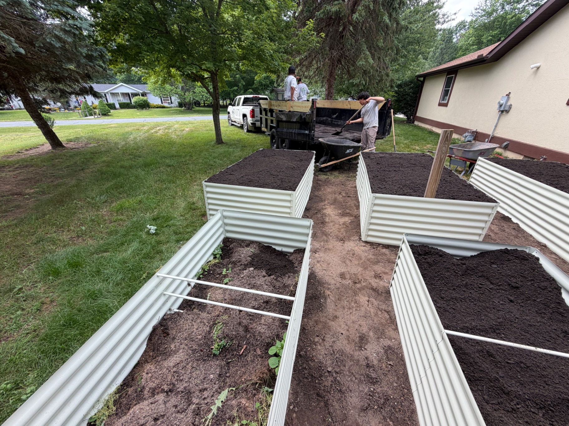 Metal raised garden beds being filled with soil